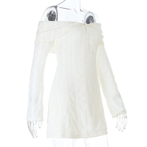 Detail of white off-shoulder lace dress featuring textured floral jacquard fabric