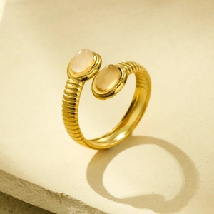 Detailed macro view of gold-plated textured open ring with two oval natural stones