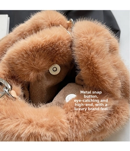 Close-up of metal magnetic snap closure and plush faux fur texture on camel bucket bag