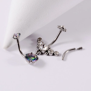 Vue macro de piercings de nombril en titane G23 avec des pierres claires et arc-en-ciel