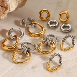 Minimalist stainless steel hoop earrings in gold and silver finish on marble background