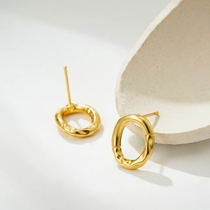 Detailed macro view of 18K gold earrings with unique balloon wrinkled texture finish