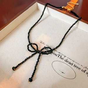 Macro view of French vintage black beaded bow necklace with elegant pearl details