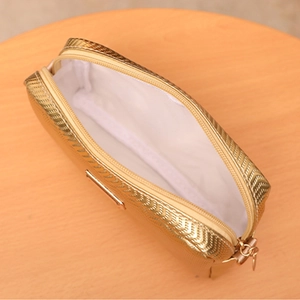 Petit sac appareil photo doré brillant avec doublure blanche et fermeture éclair sur bois