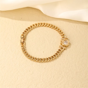Close-up of golden Cuban chain bracelet with heart-shaped zircon stone and folding clasp