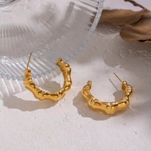 Dettaglio degli orecchini a cerchio a C placcati in oro 18K con texture effetto bambù dorato