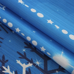 Close-up of blackout curtain fabric with blue gradient stars and snowflakes patterns