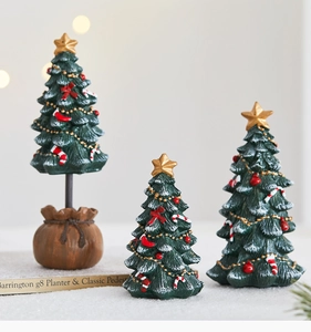 Detailed view of resin mini Christmas tree ornaments with golden stars and red baubles