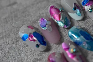 Macro detail of marble-patterned nail stickers with shell inlays and metallic accents
