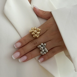 Detailed view of bubble texture rings in gold and silver finish on model's fingers