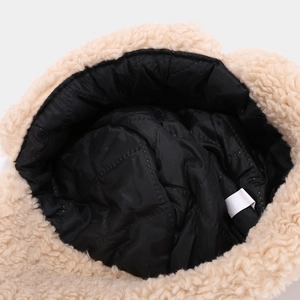 Close-up of winter trapper hat with beige faux shearling and black quilted lining detail