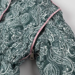 Detailed macro view of quilted paisley pattern and metal zipper on this women jacket