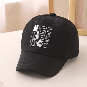 Close-up of white NICE embroidery on black cotton baseball cap for kids with curved brim