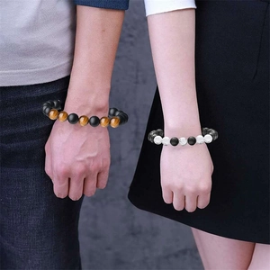 Close-up of couple wearing adjustable natural tiger eye and lava stone beaded bracelets