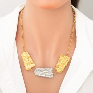 Two-tone stainless steel necklace featuring hammered metal pendants on a gold chain
