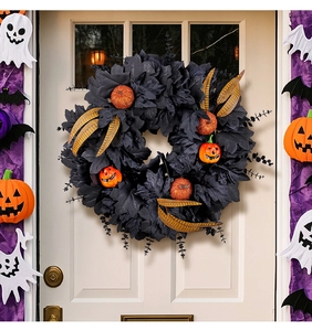 Close-up of Halloween wreath with black leaves and orange pumpkins on white door