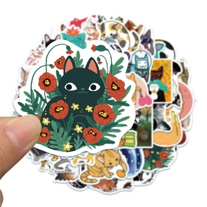 Close-up of a cute black cat sticker among red poppy flowers for laptops and journals