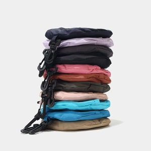 Detailed view of foldable nylon sun hats stored in colorful pouches with carabiner hooks