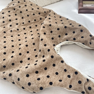 Dettaglio della borsa in velluto marrone a pois con trama del tessuto e fodera interna