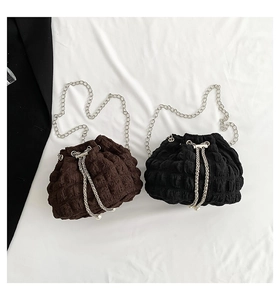 Detail of colorful chain bags with pleated texture, metal strap and pearl drawstring accent
