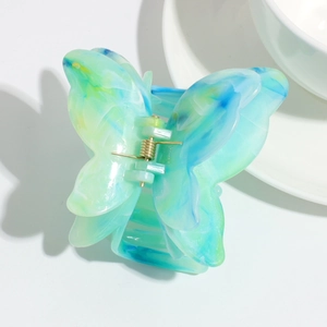 Detailed view of the gradient turquoise butterfly hair claw clip with golden metal spring
