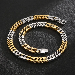 Close-up of gold and silver cuban link chain with box clasp on black background