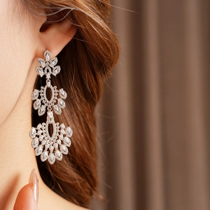 Détail de boucles d'oreilles vintage à pompons argentés portées par un mannequin