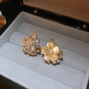 Detail of flower stud earrings with cat eye stone and cubic zirconia in a jewelry box
