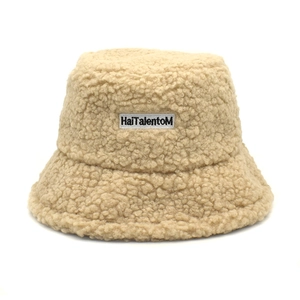 Détail du chapeau bob en sherpa beige avec texture douce et broderie de lettres