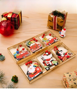 Close-up of assorted wooden Christmas ornaments featuring Santa and car in a storage box