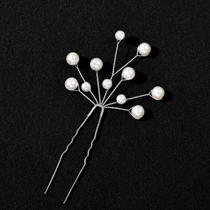 Close-up of handmade bridal U-shaped hair pin with white pearls and silver wire branches