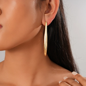 Polished 18K gold-plated vertical drop earring shown on model for elegant minimalist style