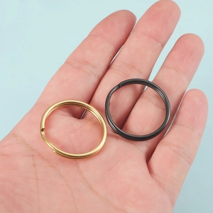 Polished stainless steel double layer key rings in gold and black finish on hand