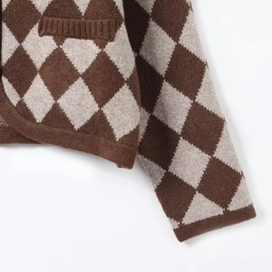 Detailed close-up of brown argyle knit pattern and ribbed texture on the cardigan