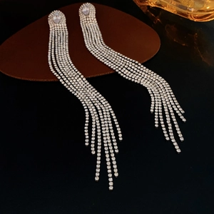 Détail macro de boucles d'oreilles argentées de luxe avec pompons en zircons brillants