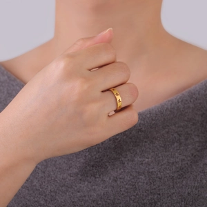 Detail of a hollow butterfly ring in gold finish worn on finger for a stylish look