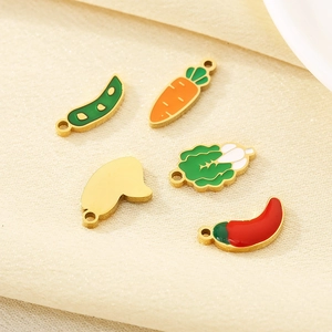 Macro shot of colorful enamel vegetable charms like peas and carrot for jewelry making