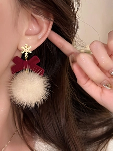 Detail of Christmas snowflake stud earring with red velvet bow and white pompom