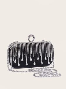 Detailed close-up of black satin evening clutch featuring sparkling rhinestone tassels