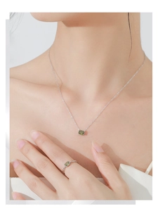 Close-up of S925 silver necklace and ring set with oval olive green gemstones