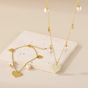 Golden heart pendant necklace and pearl bracelet set with sparkling crystal stones