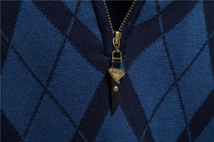 Detailed view of dark blue argyle knit sweater with high neck metal zipper closure