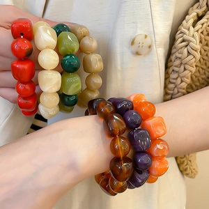 Détail d'un bracelet en perles acryliques irrégulières colorées avec texture marbrée au poignet