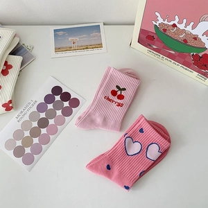 Detail of pink cotton knit crew socks with cherry embroidery and heart patterns