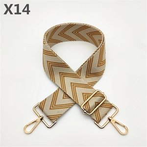 Detail of wide woven strap with geometric herringbone pattern and golden metal buckles