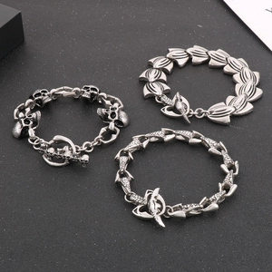 Detailed shot of three punk style stainless steel bracelets with skull and anchor charms