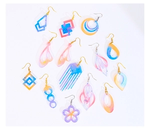 Detailed view of colorful resin earrings in geometric and butterfly wing shapes with glitter