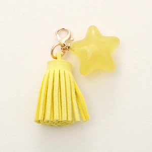 Yellow star keychain with fringe tassel and golden clasp on a clean white background