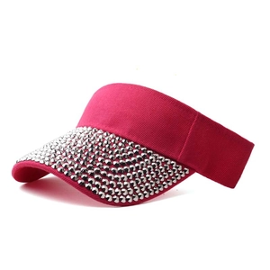 Detail of hot pink sun visor featuring rows of shiny silver metal rhinestones on the brim