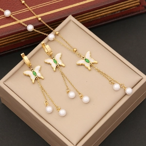 Golden butterfly jewelry set with green stones and white pearl tassel on necklace and earrings